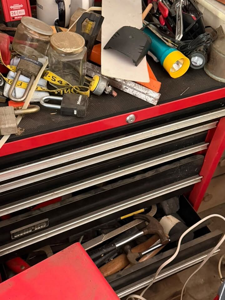 Red rolling tool chest full of hand tools